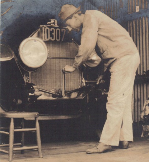 Rockville Garage mechanic hand cranking old car