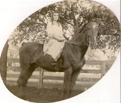 woman holding rifle on horse