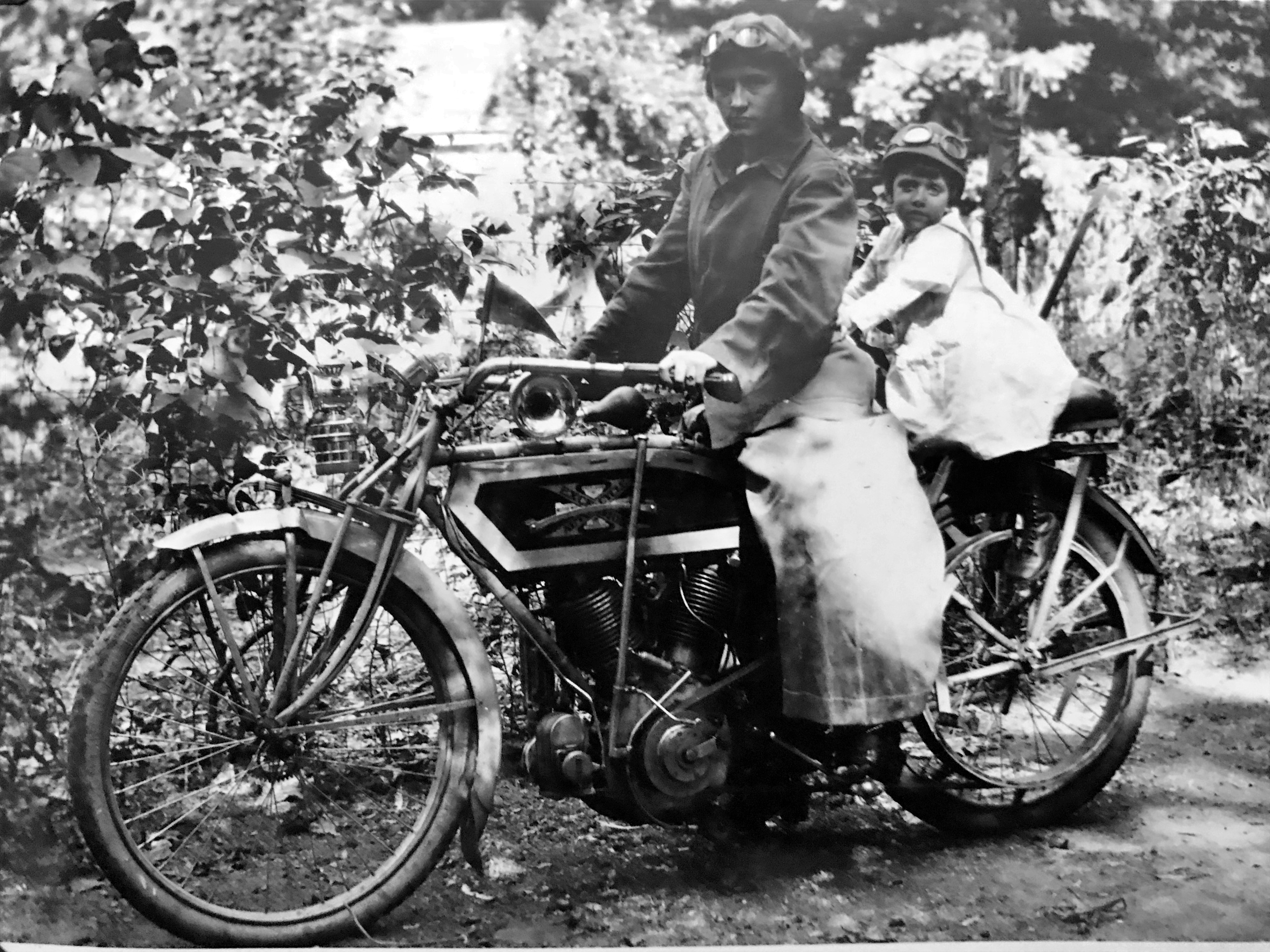 Woman and toddler pose on an Excelsior motorcycle. 